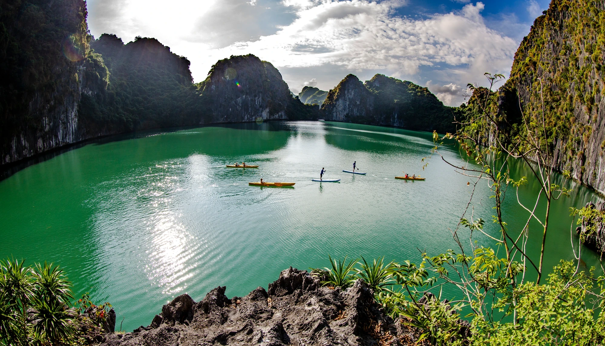 Kayaks on sheltered Lan Ha Bay water among limestone islands